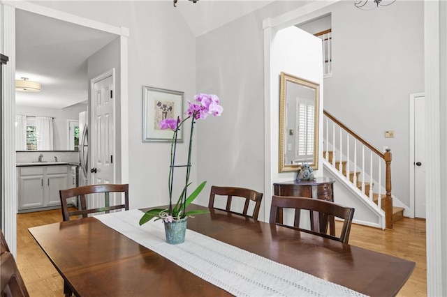 dining space featuring light wood finished floors and stairs