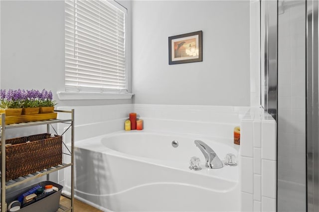 bathroom featuring tiled shower and a bath
