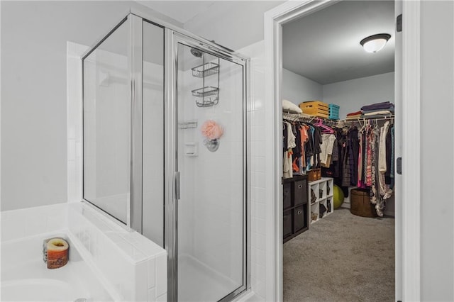 full bath with a stall shower, a spacious closet, and a garden tub