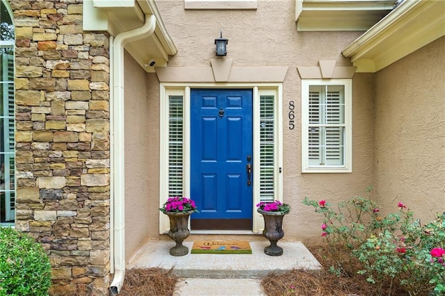 property entrance with stone siding and stucco siding