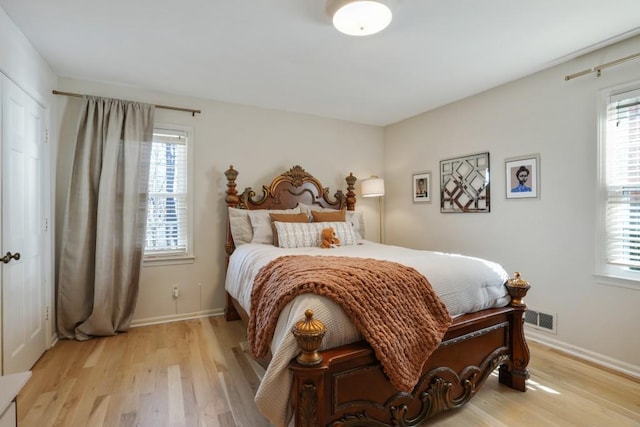 bedroom with multiple windows, visible vents, and light wood finished floors