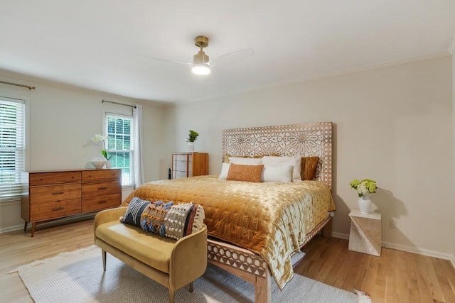 bedroom with crown molding, light wood-style flooring, and baseboards