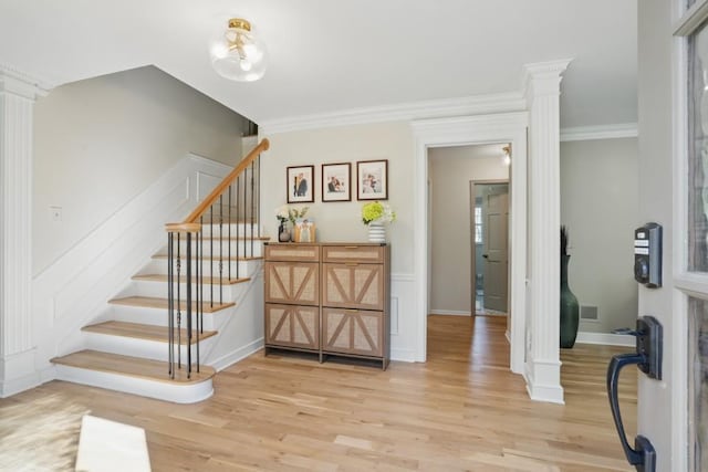 stairway featuring visible vents, crown molding, baseboards, and wood finished floors