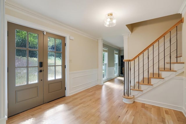 entrance foyer with stairway, french doors, wood finished floors, and ornamental molding