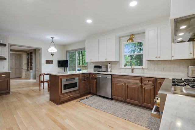 kitchen with decorative backsplash, appliances with stainless steel finishes, light countertops, and a sink