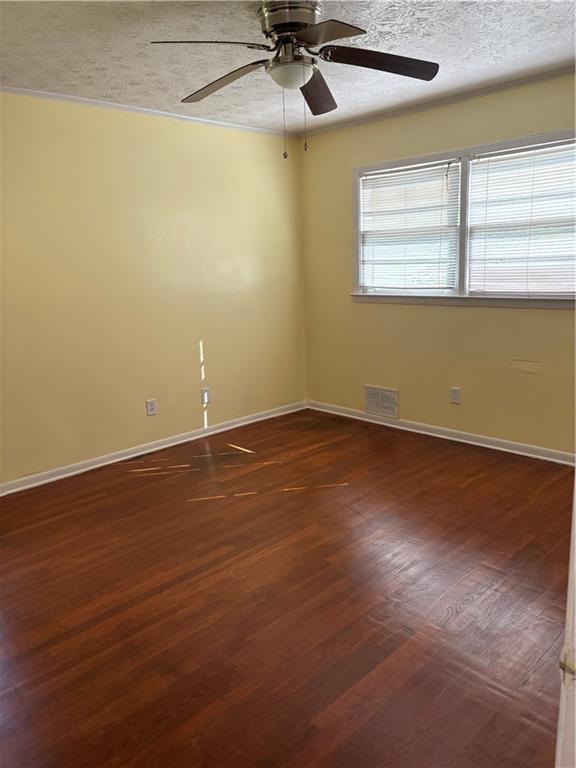 801 Needle Rock Dr, Stone Mountain, GA 30083 - unfurnished room featuring a ceiling fan, baseboards, dark wood-style flooring, and a textured ceiling