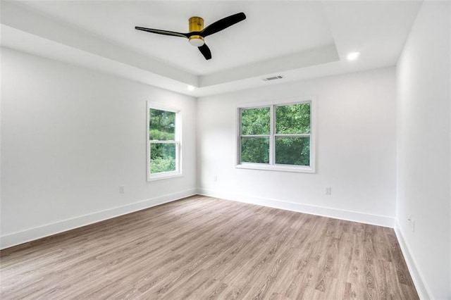 597 Woodcrest Manor Dr, Stone Mountain, GA 30083 - unfurnished room featuring a tray ceiling, light wood-style floors, and ceiling fan