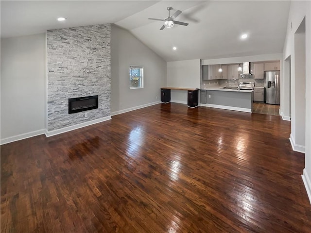 unfurnished living room with ceiling fan, dark wood-style flooring, a fireplace, baseboards, and vaulted ceiling