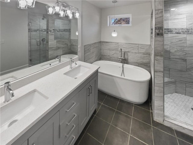 bathroom featuring a stall shower, a soaking tub, a sink, and double vanity