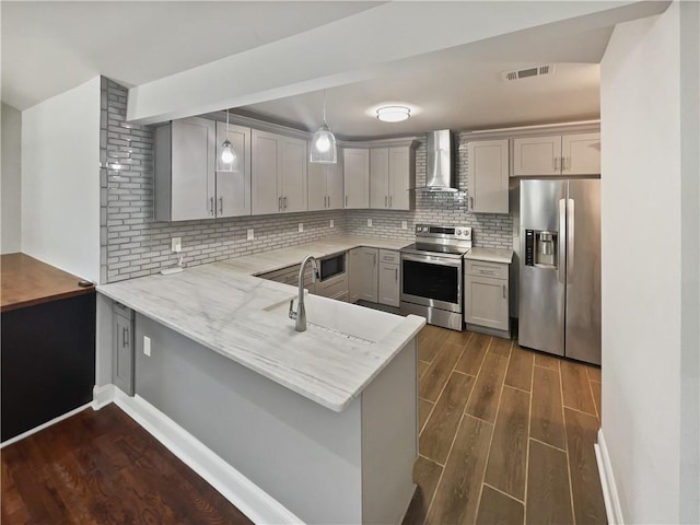 kitchen with visible vents, dark wood-style floors, gray cabinets, stainless steel appliances, and wall chimney range hood