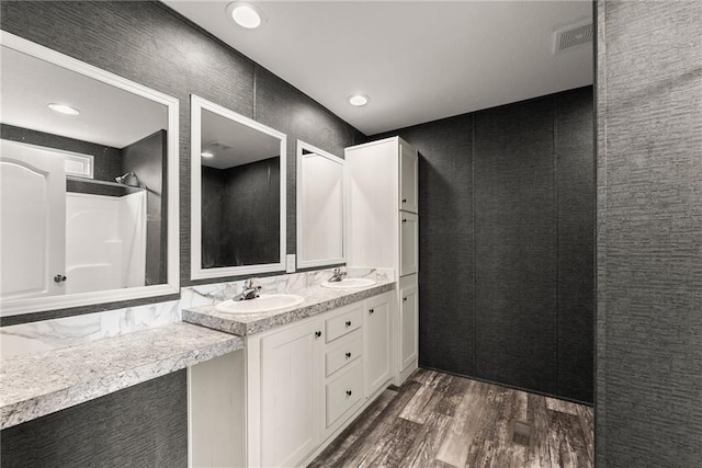 bathroom featuring wood-type flooring, vanity, and a shower