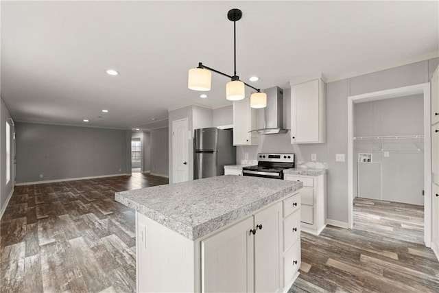 kitchen with white cabinetry, hanging light fixtures, a kitchen island, stainless steel appliances, and wall chimney range hood