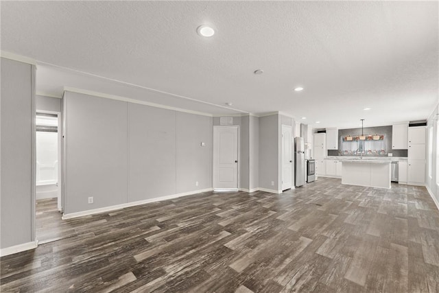 unfurnished living room with a textured ceiling and dark hardwood / wood-style flooring