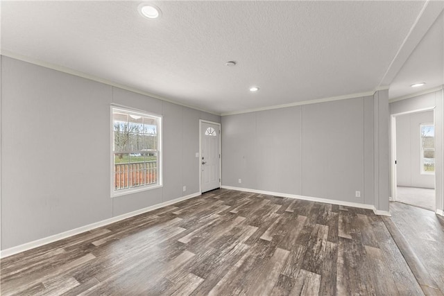 spare room featuring crown molding, plenty of natural light, and dark hardwood / wood-style flooring