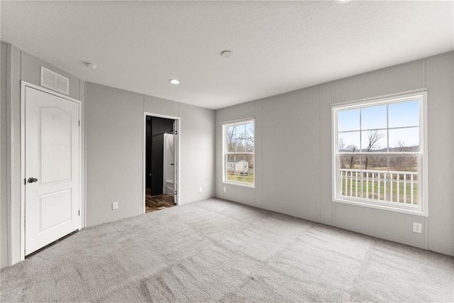 unfurnished bedroom featuring carpet flooring and ensuite bath