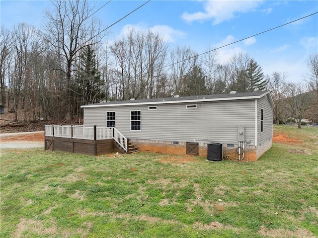 rear view of house with central AC, a lawn, and a deck