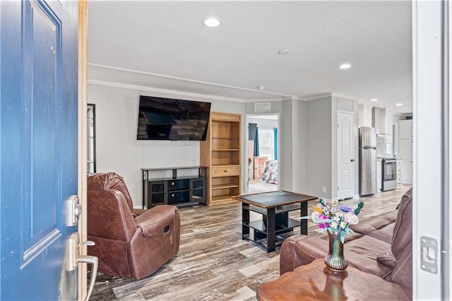 living room with hardwood / wood-style flooring and crown molding