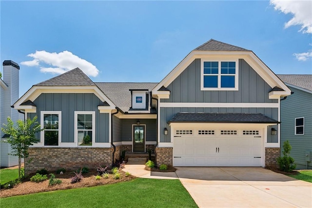 view of front facade with board and batten siding, concrete driveway, brick siding, and roof with shingles