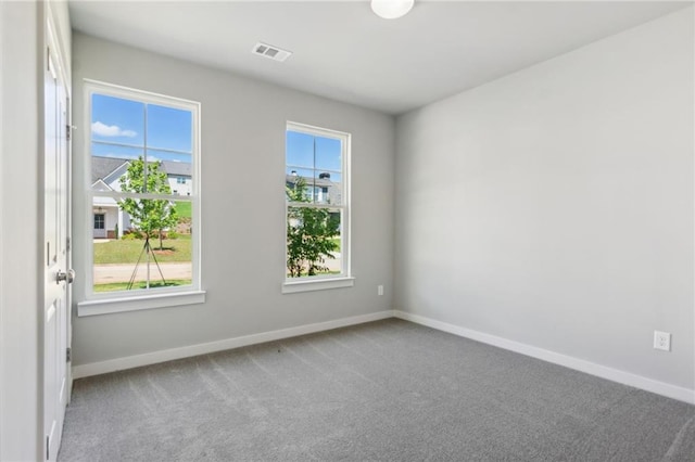 carpeted empty room with visible vents and baseboards