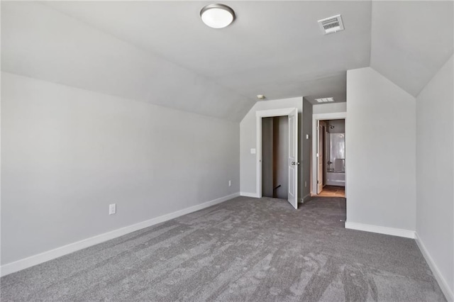 additional living space featuring lofted ceiling, carpet, baseboards, and visible vents