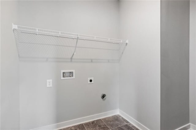 washroom with hookup for an electric dryer, laundry area, washer hookup, dark tile patterned floors, and baseboards