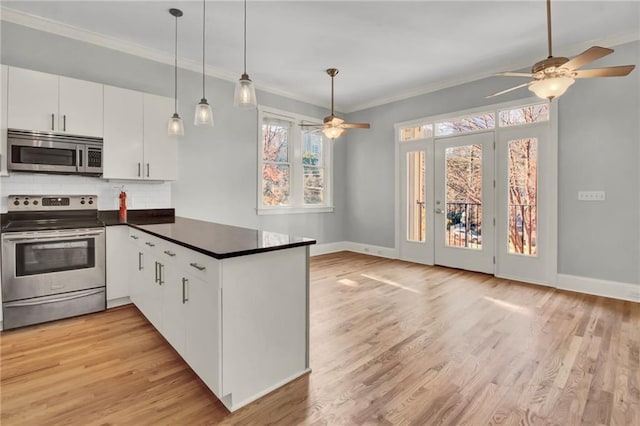 kitchen featuring backsplash, kitchen peninsula, white cabinets, and appliances with stainless steel finishes