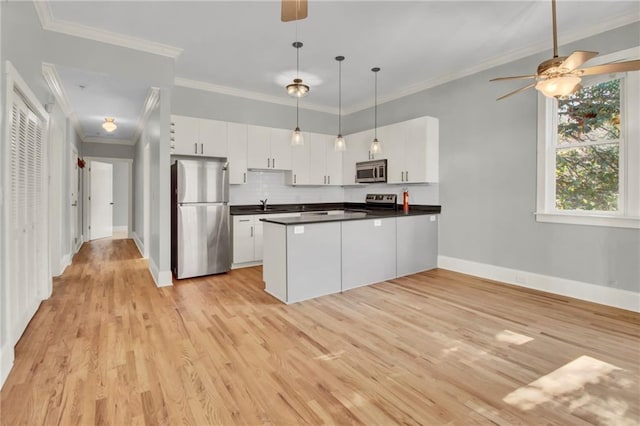 kitchen with tasteful backsplash, light hardwood / wood-style flooring, pendant lighting, white cabinets, and appliances with stainless steel finishes