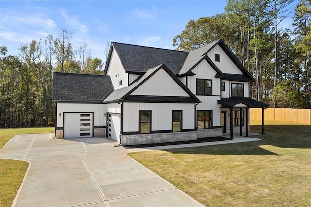 modern inspired farmhouse with a front yard and a garage