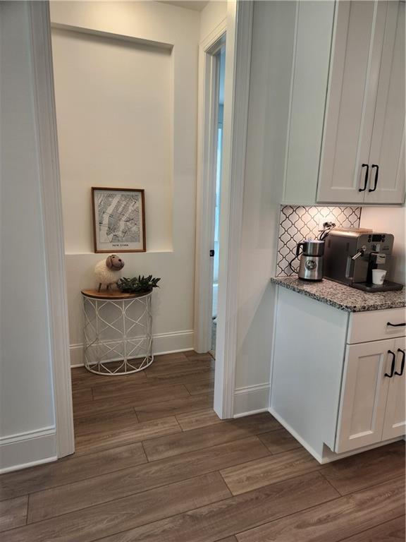 hallway with baseboards and dark wood-type flooring