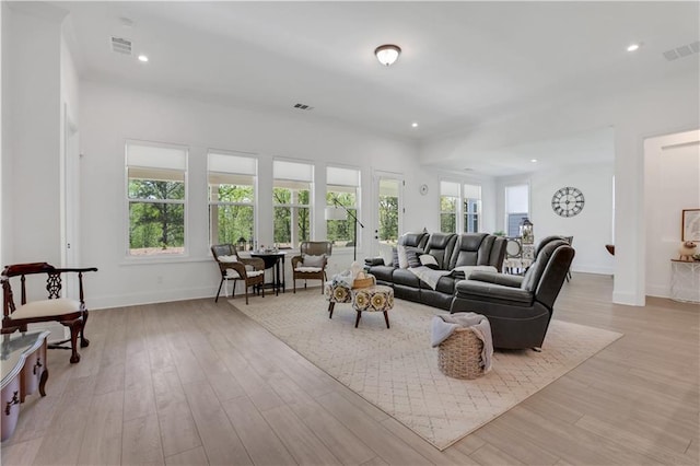 living room with plenty of natural light, baseboards, visible vents, and light wood-type flooring