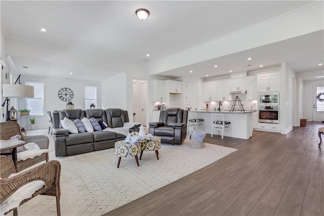 living room with dark wood-type flooring, recessed lighting, and baseboards