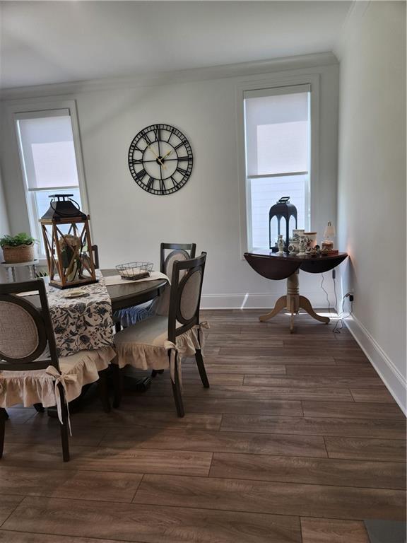 dining space with baseboards, dark wood-style floors, and ornamental molding