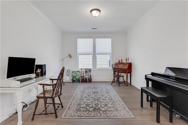 office space with crown molding, wood finished floors, and visible vents