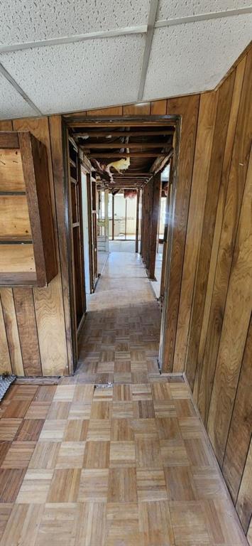 hallway featuring wooden walls