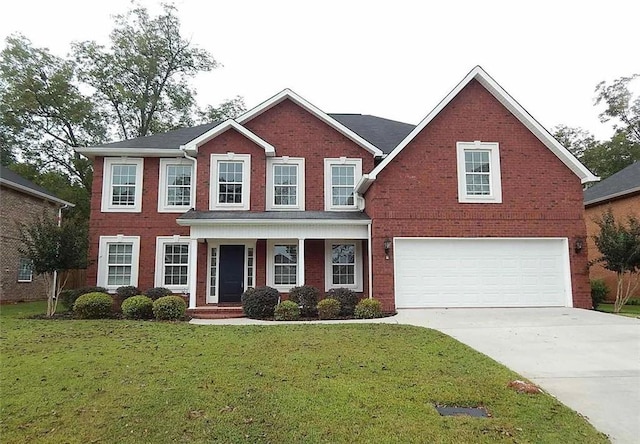 colonial-style house featuring a front yard, brick siding, driveway, and an attached garage