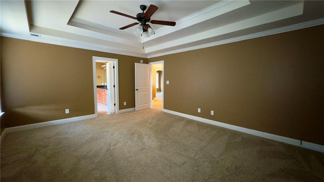 unfurnished bedroom with crown molding, carpet, a raised ceiling, and baseboards