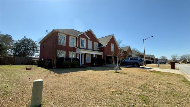 view of front of property featuring a garage, fence, a front lawn, and concrete driveway