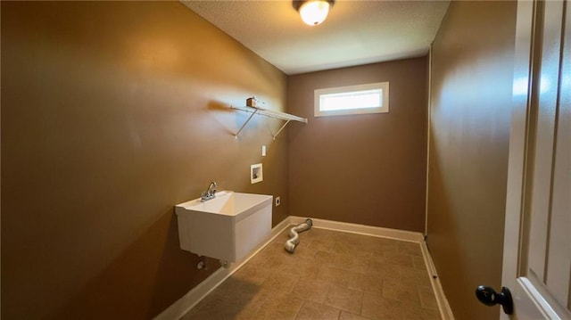 washroom featuring laundry area, washer hookup, a sink, and baseboards