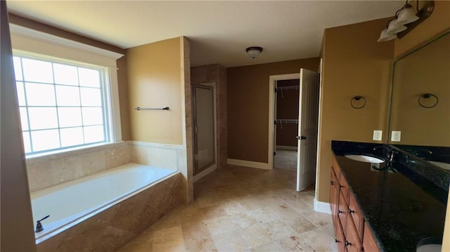 bathroom featuring a sink, a shower stall, a bath, and double vanity