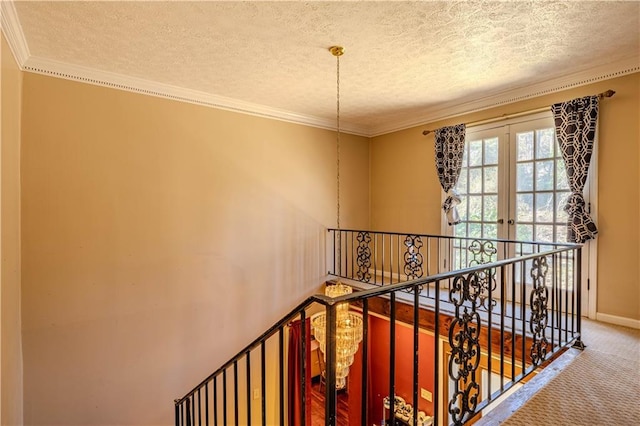 stairway featuring ornamental molding, carpet flooring, a textured ceiling, and baseboards