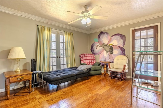 sitting room featuring a wealth of natural light, crown molding, hardwood / wood-style floors, and french doors