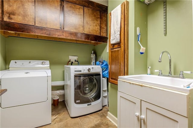 laundry room with cabinet space, a sink, and independent washer and dryer