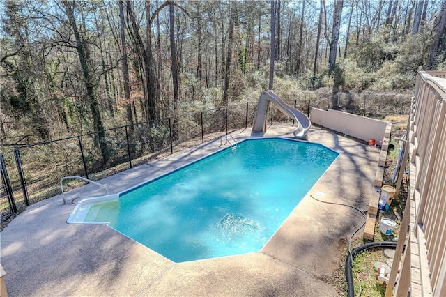 view of pool featuring a fenced in pool, a water slide, a patio area, and fence