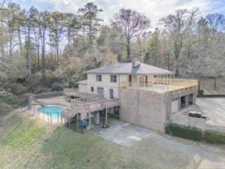 rear view of property featuring a patio and driveway