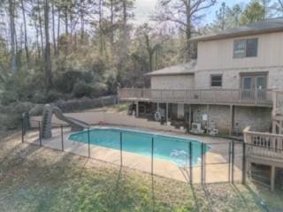 view of swimming pool with a patio area, a fenced in pool, and a water slide