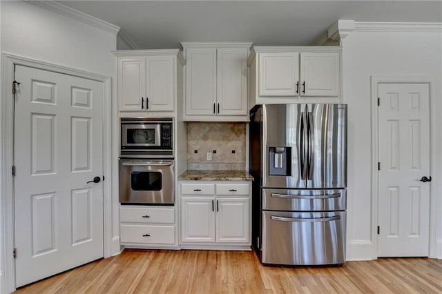 kitchen featuring ornamental molding, decorative backsplash, stainless steel appliances, white cabinetry, and light wood-type flooring