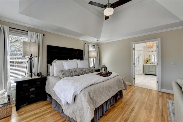 bedroom featuring a tray ceiling, ornamental molding, and light wood finished floors