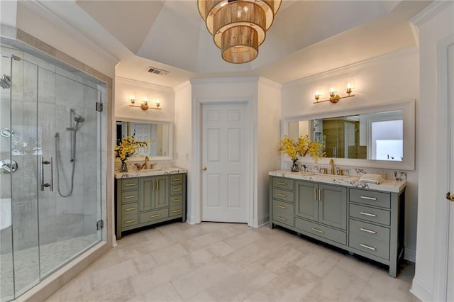 full bathroom with crown molding, two vanities, a stall shower, and a sink