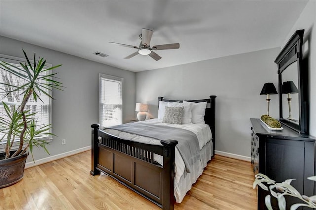 bedroom with visible vents, baseboards, light wood-style floors, and a ceiling fan