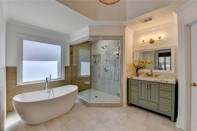 full bathroom featuring vanity, visible vents, a freestanding tub, ornamental molding, and a shower stall